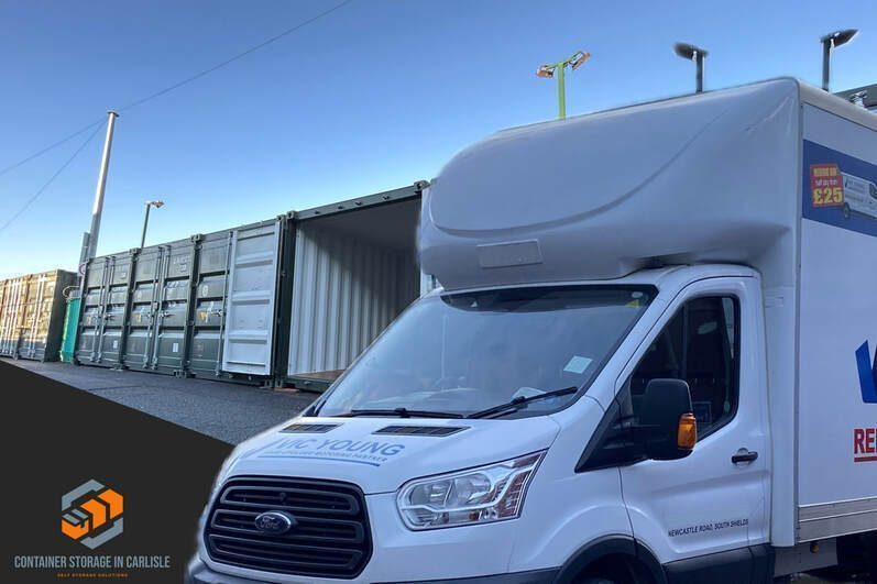 van loading into a shipping container on a storage facility showing a row of shipping containers