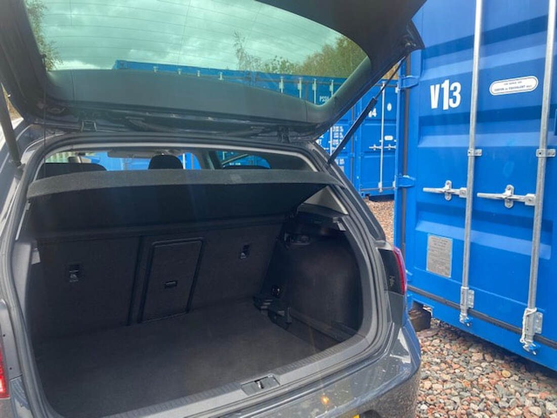 car with boot open at a shipping container